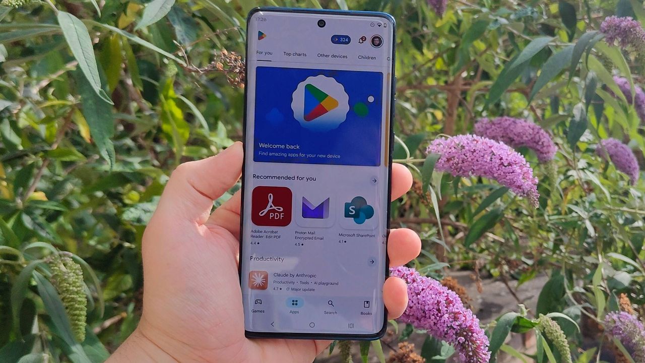 The Motorola Edge 60 in front of a flowery bush.