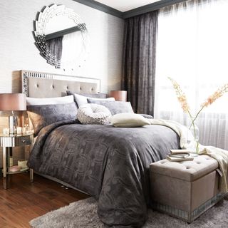 bedroom with grey bedding and wooden flooring