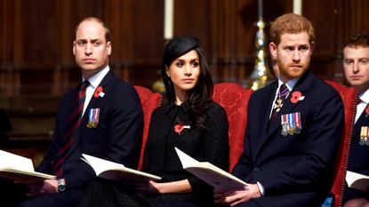 Prince William, Meghan Markle, and Prince Harry sit at a formal event.