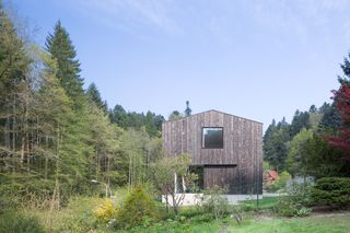 Black Forest House by Stocker Dewes Architekten. A large double storey wooden cabin in the middle of a forest.