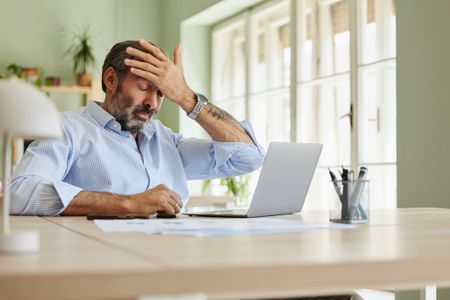 A frustrated man working at his computer. 