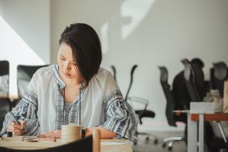 A woman working alone in a half-empty office