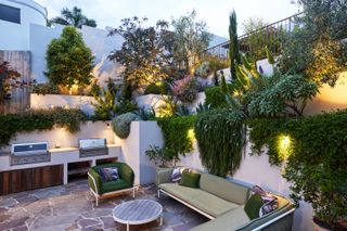 An outdoor kitchen with a small seating area