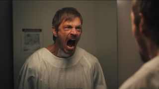 Joel Kinnaman tries to scream in the mirror in Silent Night.