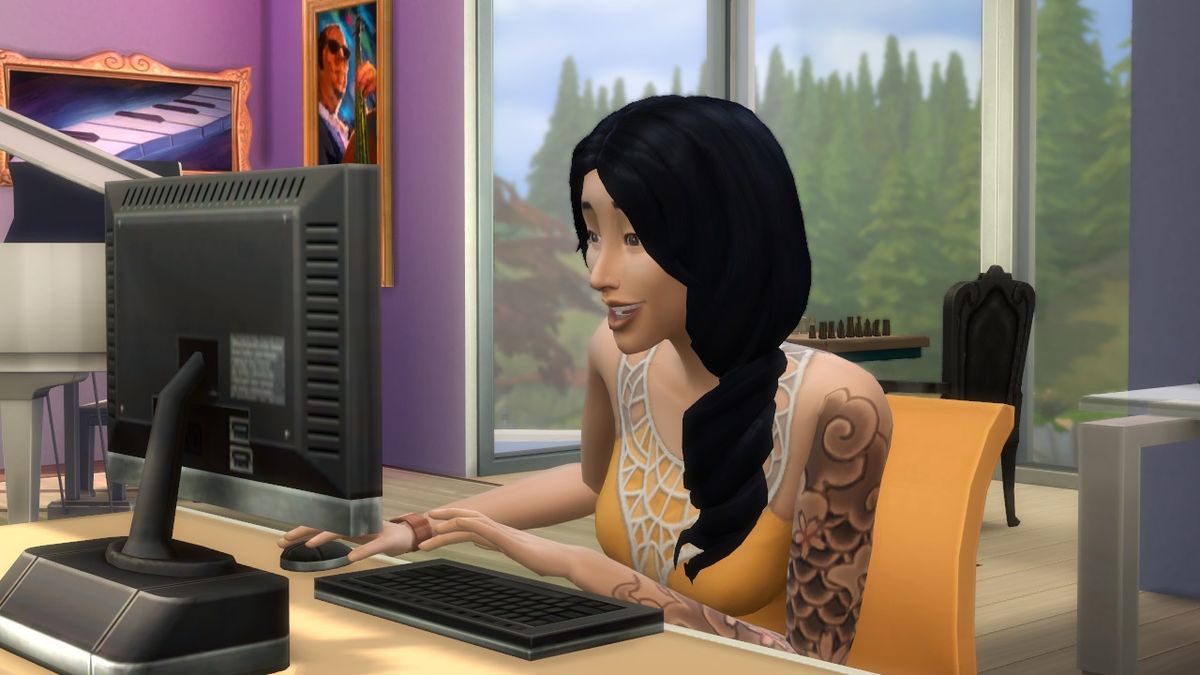 The Sims 4 - A sim plays on a computer with a smile