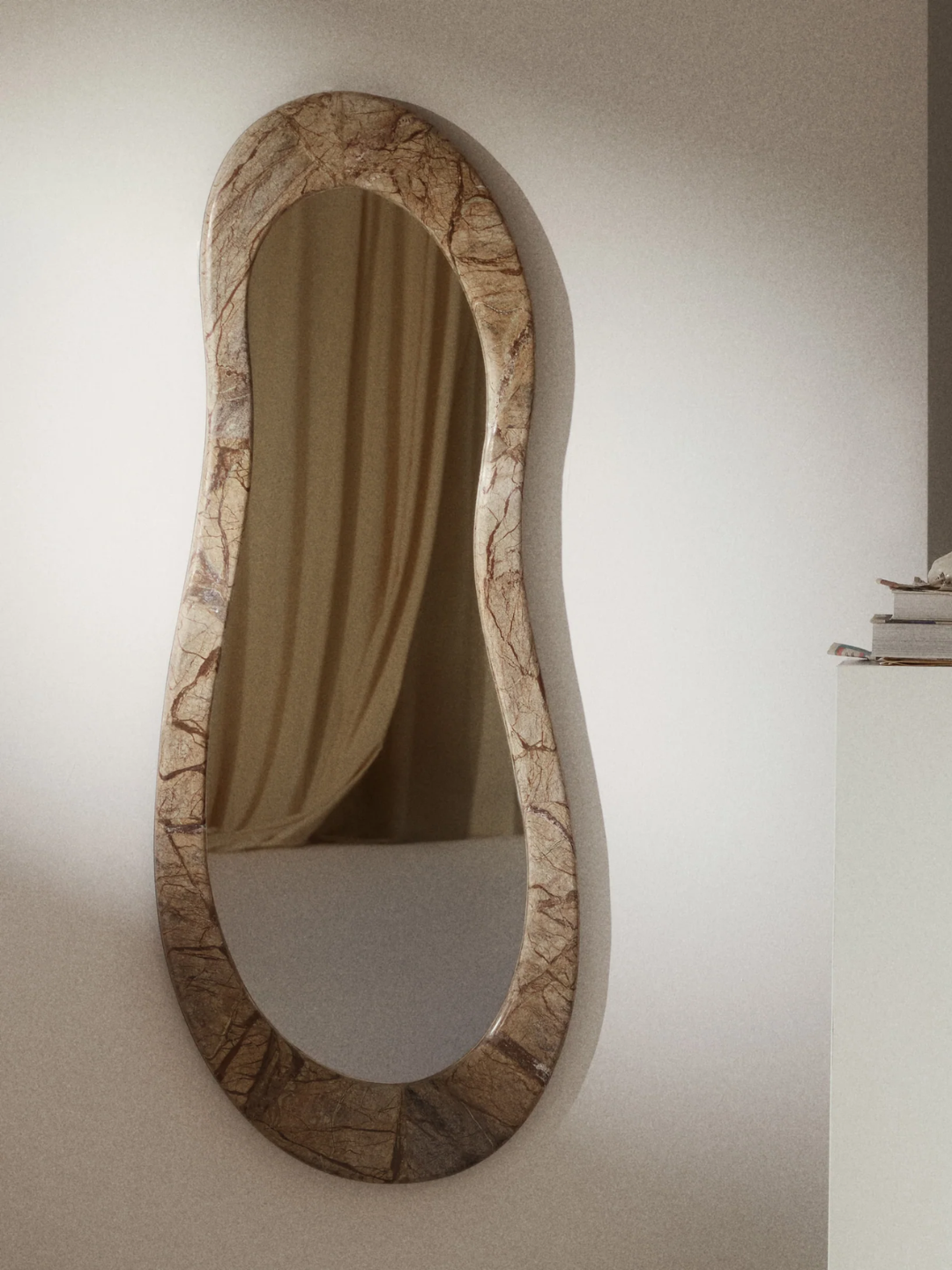 A curved long marble framed wall mirror