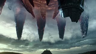 Still from the movie Transformers: Rise of the Beasts. An ominous-looking spaceship opening up over a mountain.