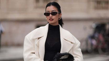 woman wearing sunglasses, white coat and black high neck top