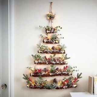 A Christmas tree alternative wall hanging with branches and red berries