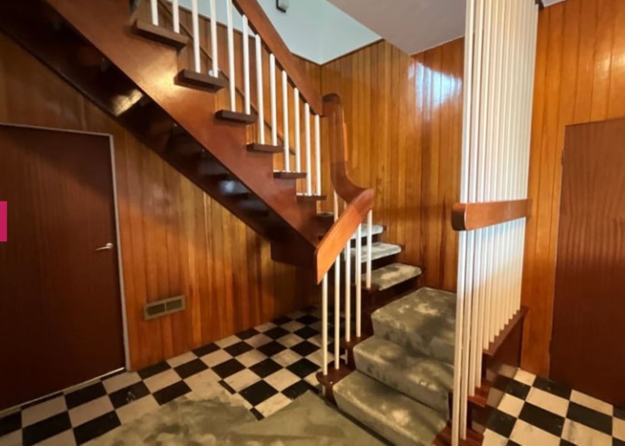 Chequered floor pattern leads up to the stairs