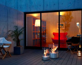 Bioethanol fire pit from lime lace in modern decked courtyard