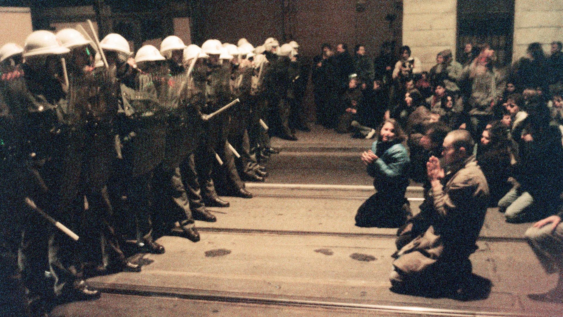 Hundreds of Czechoslovakian students kneel as they face riot police 19 November 1989 in downtown Prague during a protest rally.