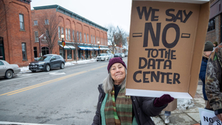 A resident holding a placard which rejects the installation of data centers