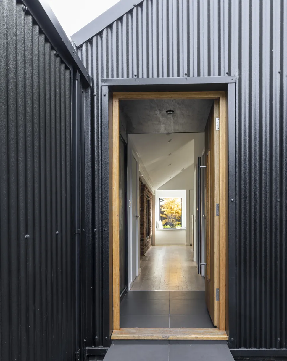 an exterior view of a small hallway idea leading through to a larger space