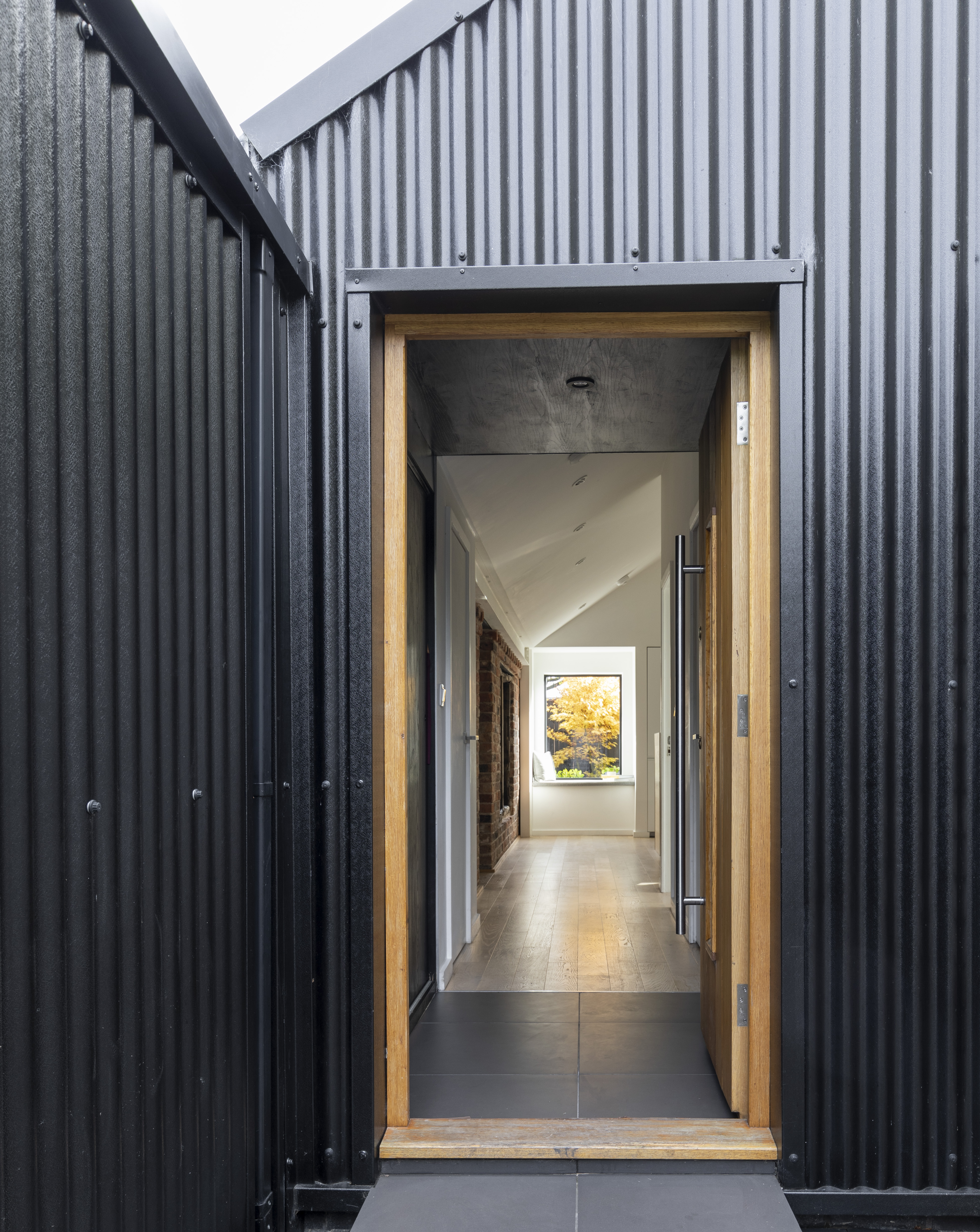 an exterior view of a small hallway idea leading through to a larger space