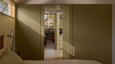 An olive green wardrobe in a small bedroom