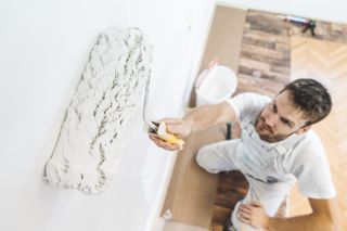 Man painting a wall when decorating