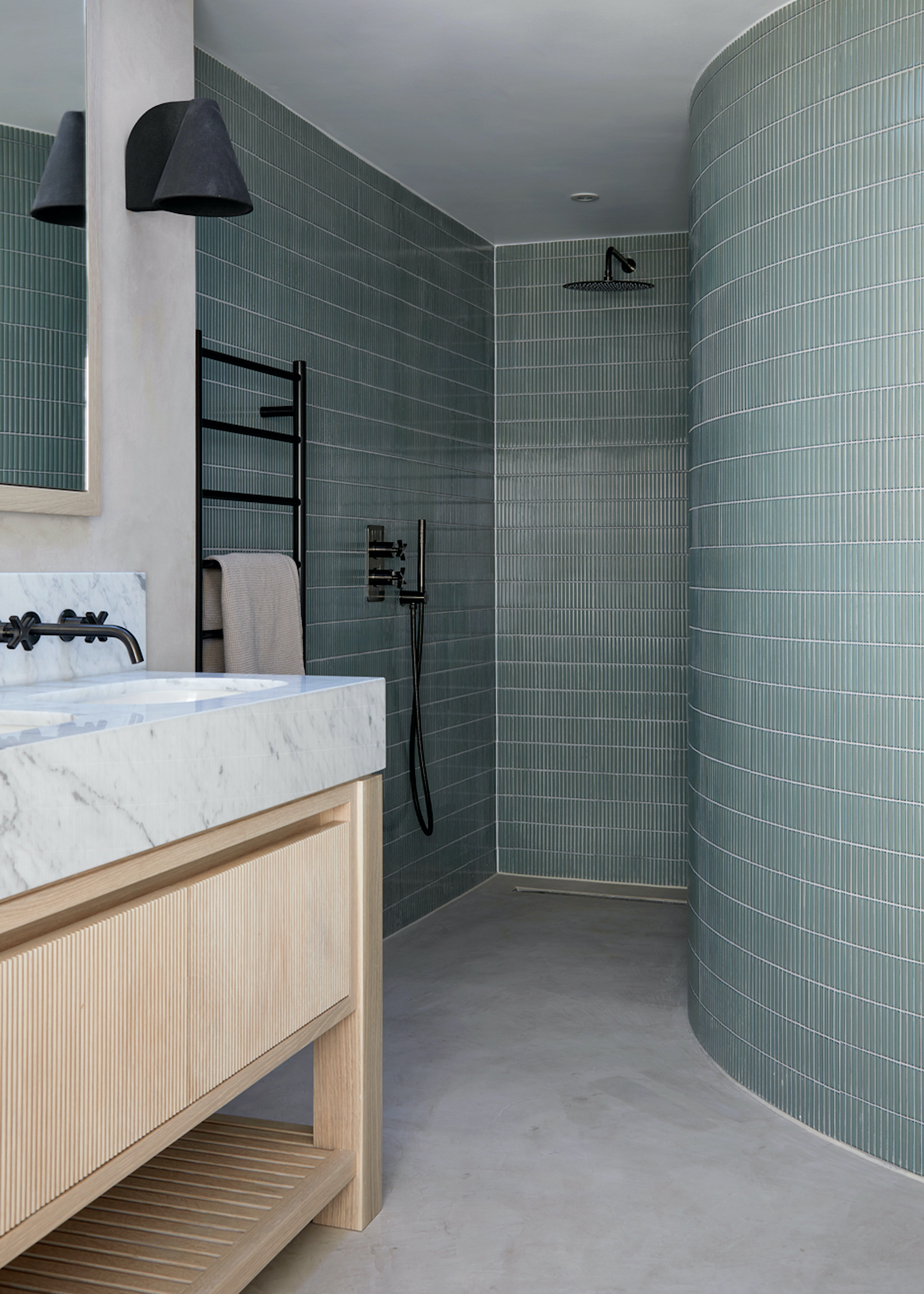 bathroom with curved wall shower and wood vanity