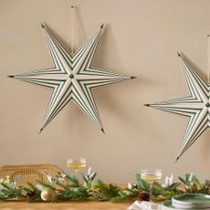 Green stripe star hanging on a beige wall