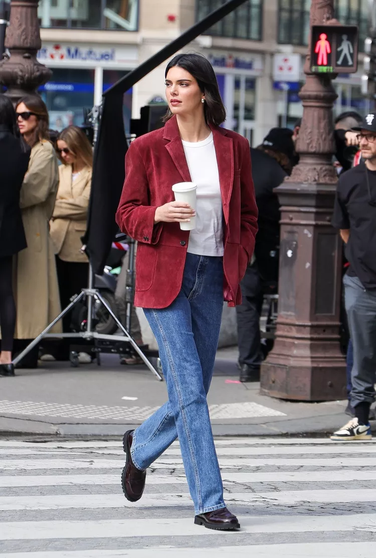 Kendall Jenner wearing a burgundy blazer, jeans, and burgundy red loafers