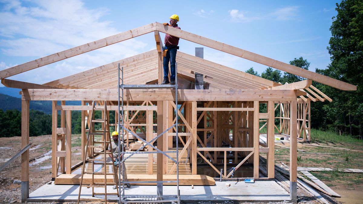 Construction Workers Working On Wooden Roof Of House