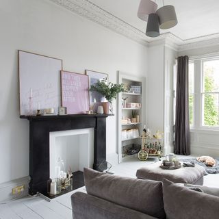 White living room with black fire surround used for a layered display of framed art prints