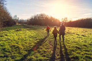 A family on a walk in a field at sunset