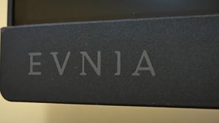 A black Philips Evnia 25M2N3200W monitor sitting on a wooden desk