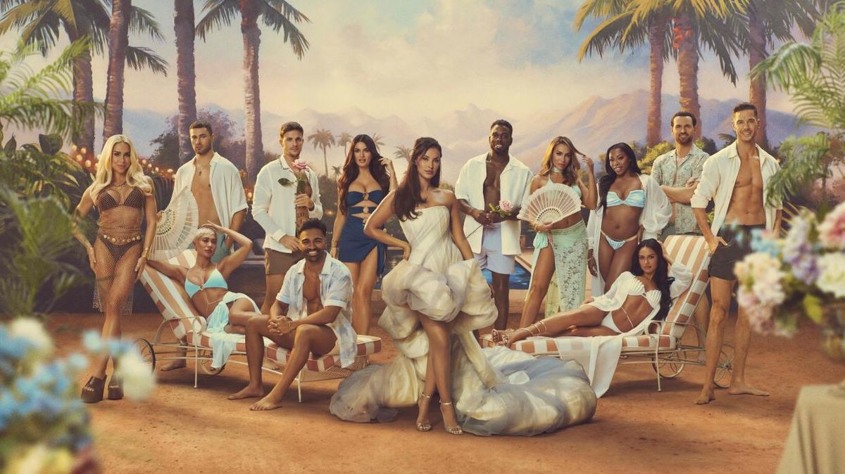 A stylishly dressed Maya Jama stands at the head of a new contingent of love-seeking contestants as they pose for the camera against a lush tropical backdrop for Love Island: All Stars season 2.