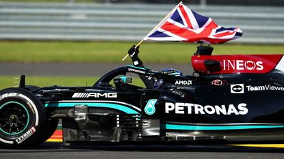 Race winner Lewis Hamilton of Great Britain driving the (44) Mercedes AMG Petronas F1 Team Mercedes W12 waves the Union Jack to celebrate during the F1 Grand Prix of Great Britain at Silverstone on July 18, 2021