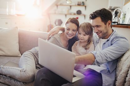 Close up of a happy young family at home surfing the net together