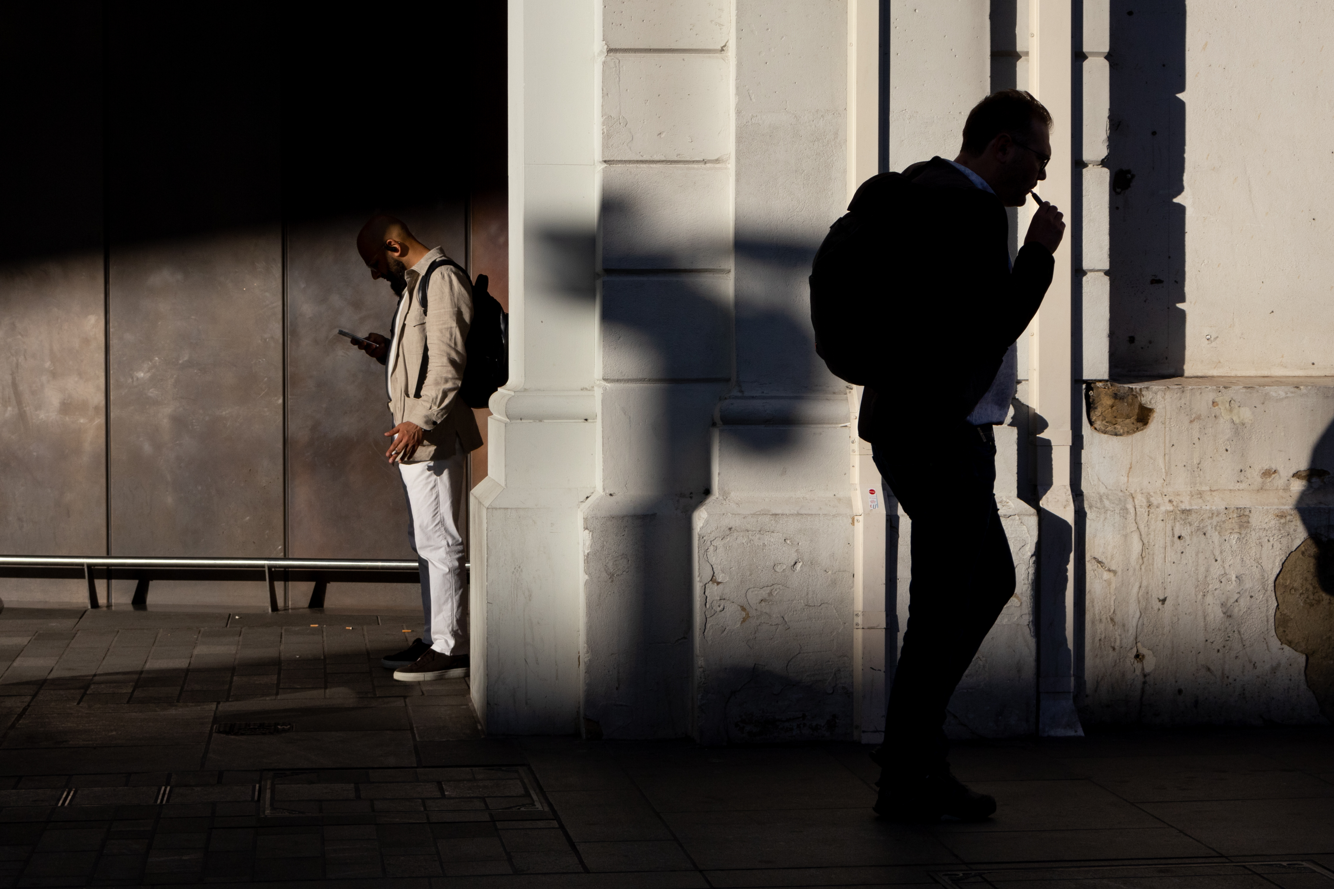 Мужчина, стоящий в тени на станция, читающая его телефон