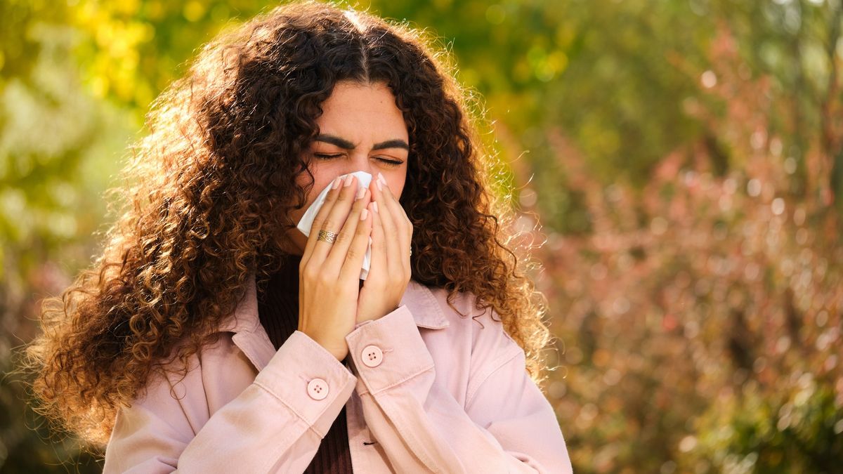 a woman blows her nose outside