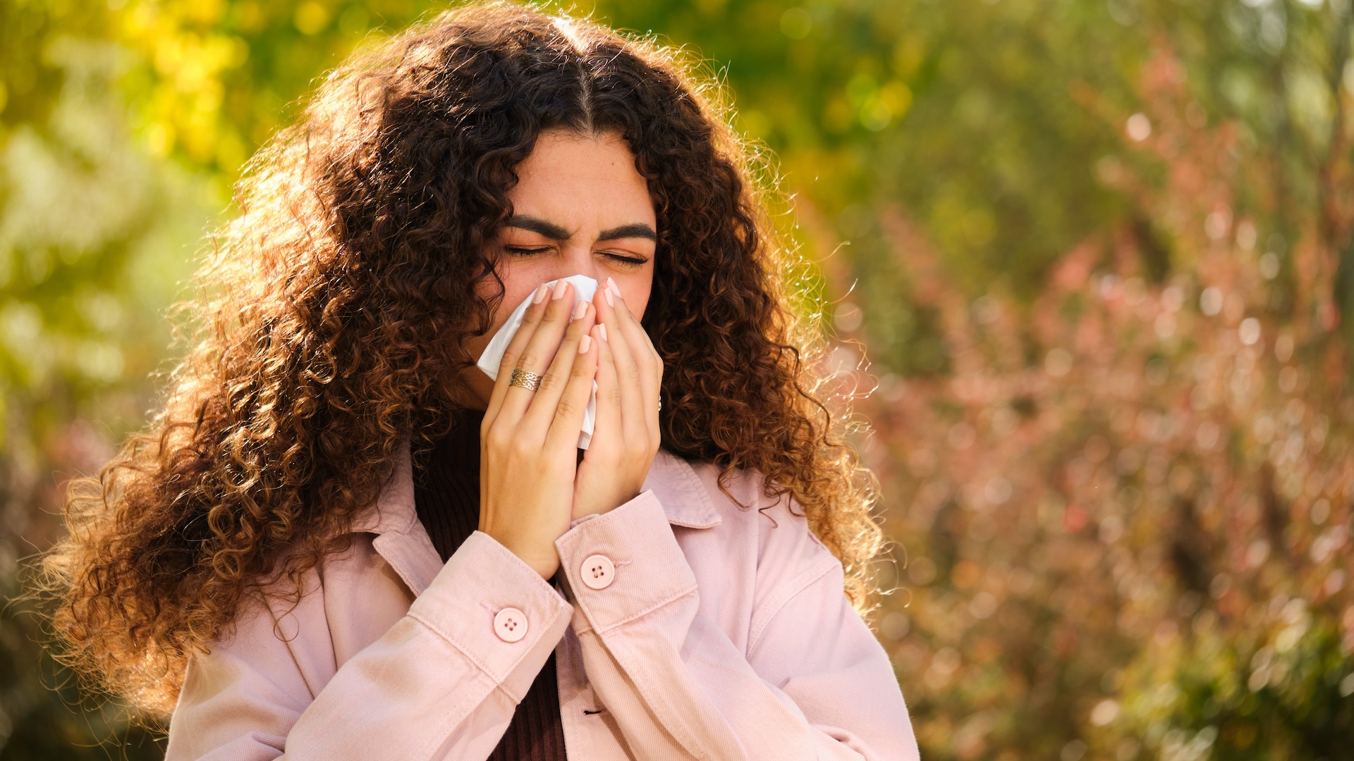 a woman blows her nose outside