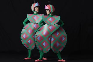 two women wearing geometric theatrical costumes