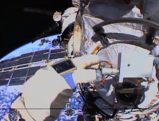 Russian cosmonaut Alexander Misurkin takes biological samples of surfaces outside the International Space Station in this helmet camera view from a spacewalk on Aug. 22, 2013.