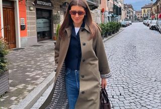 Woman in trench coat and jeans.