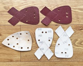 Coarse grit sandpaper pads on a wooden table