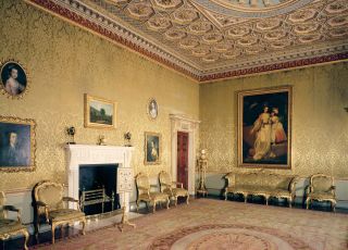 Interior of the drawing room at Osterley Park and House with a fireplace and art hanging on the wall