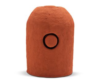 Orange/brown sculpture with rounded top and a circular shape cut into the middle