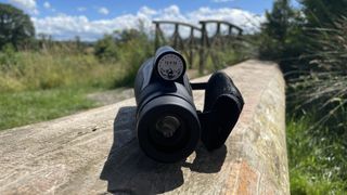 Python 12x52 Range Master Ultra HD Monocular on a wooden surface in a park