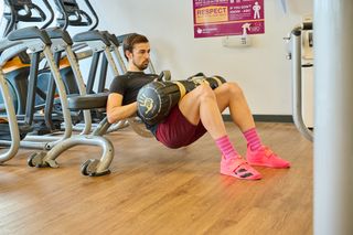 Andy Turner doing a weighted glute bridge as part of his 12 week strength training program for cyclists