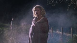 Brittany Snow wearing a blanket in a field at night in X