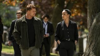 Alan Ritchson looking at Maria Sten while both are walking in the fall in an episode of Neagley Season 1.