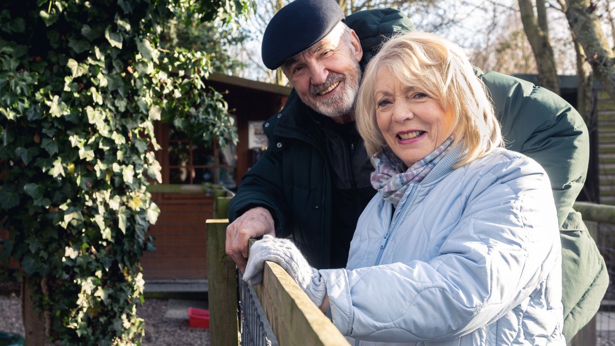 Larry Lamb in a dark hat and jacket stands next to Alison Steadman in a pale blue coat in Alison &amp; Larry: Billericay to Barry