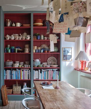 kitchen dining space with open shelving with red shiplap interior, books and crockery, dining table, Farrow & Ball : Asger Mortensen, Wester Agency