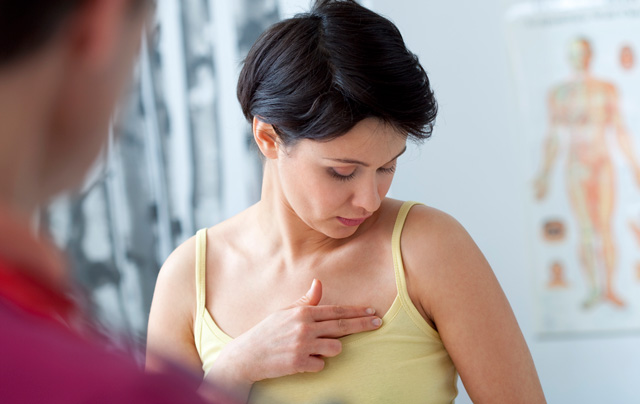 Woman with breast pain touching her breast
