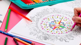 Best coloured pencils; a person colours a spiral design on paper surrounded by pencils