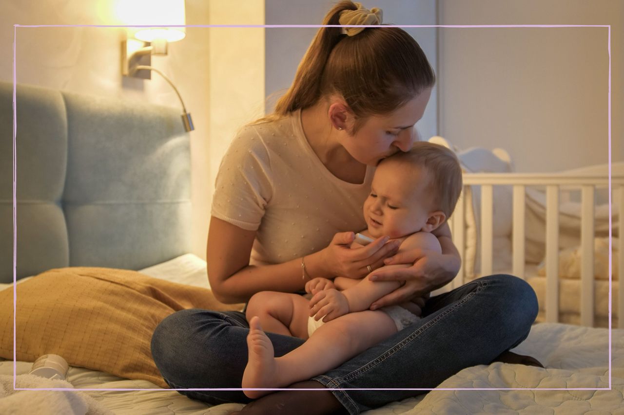 A woman sat with a baby in bed during the night