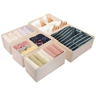 Light pink fabric folding organizing bins filled with folded clothes